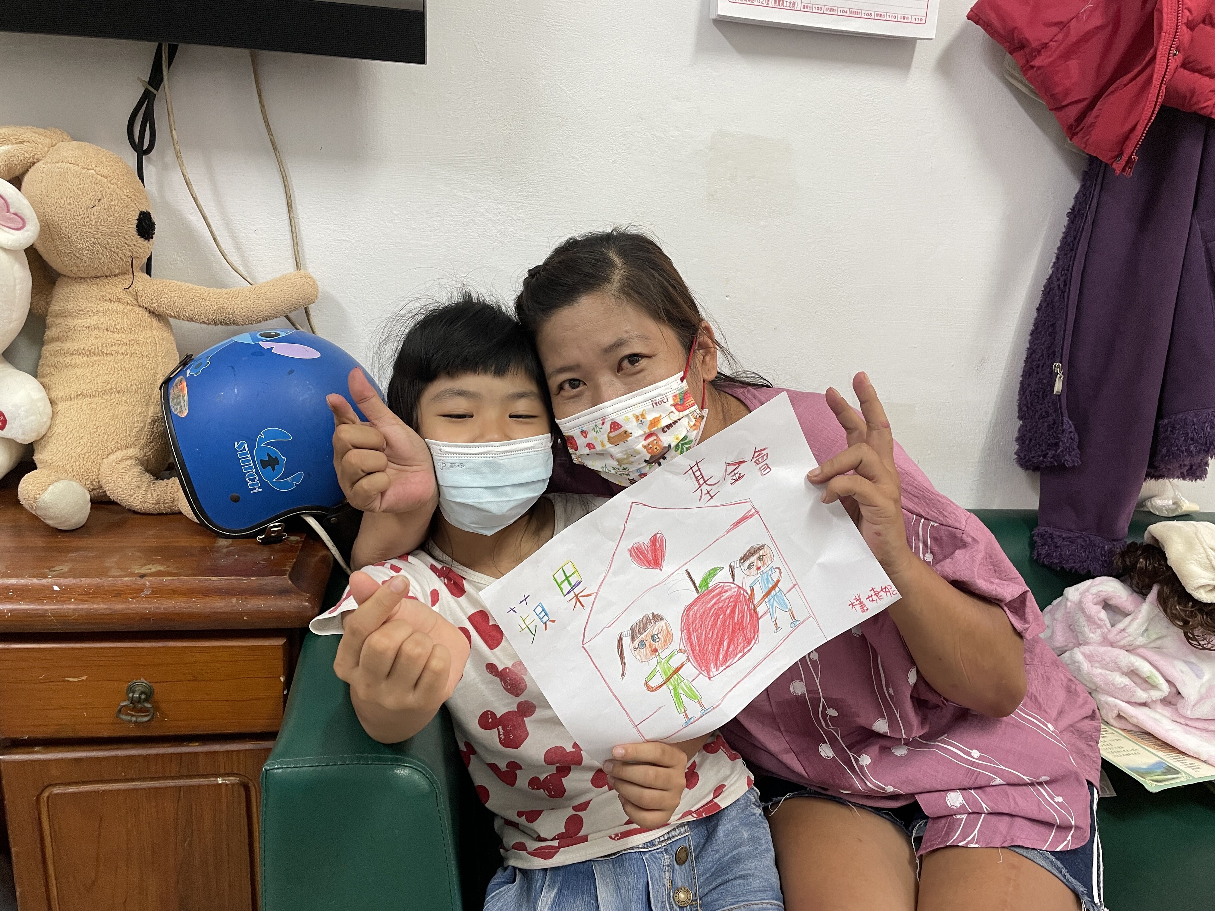 9歲女兒手繪可愛畫作和媽媽阿紅(右)感謝蘋果慈善基金會捐款人。李佳玲攝