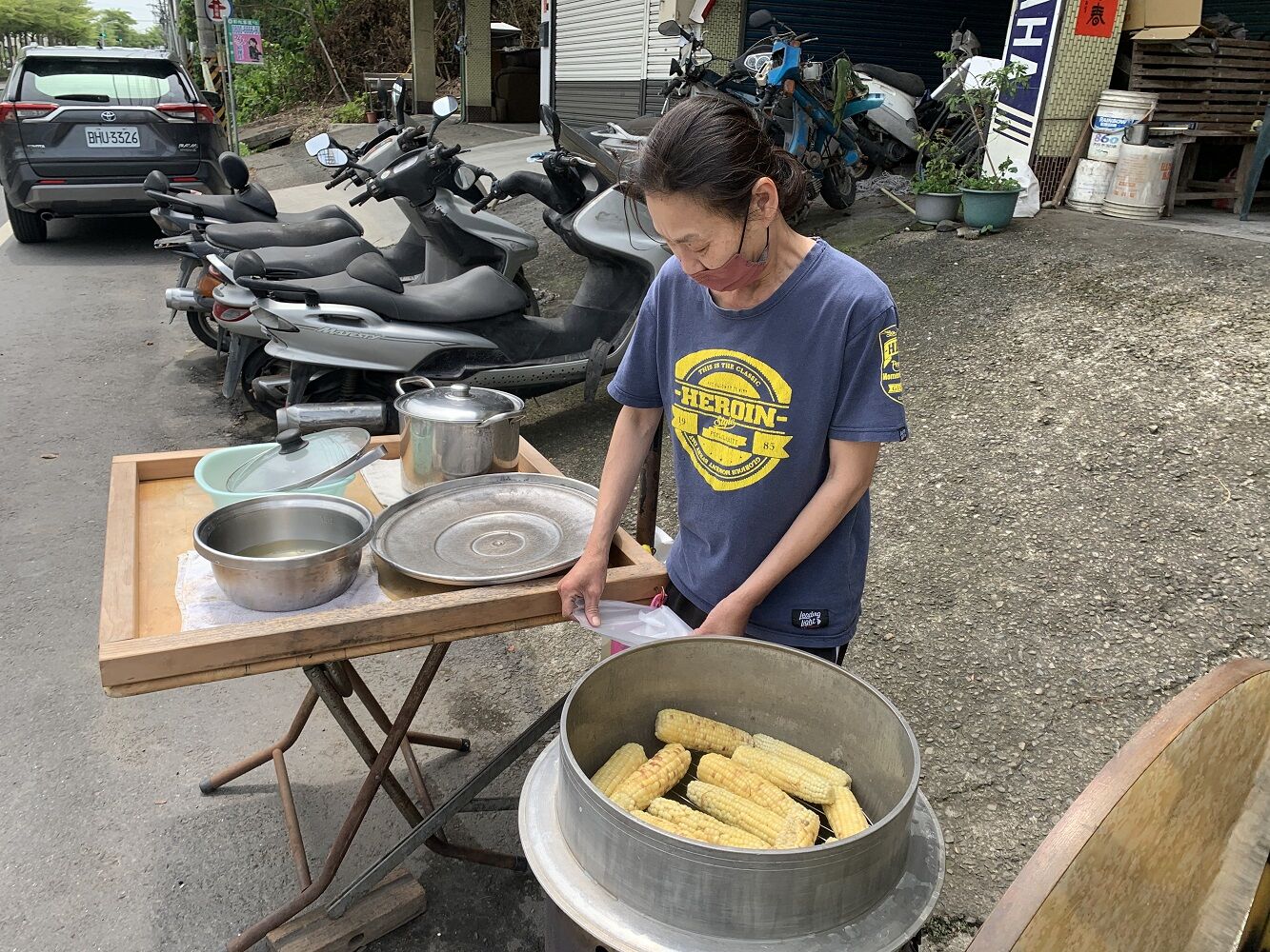 阿芬姨在路口擺攤賣水煮玉米維生，一根僅售20元。江品璁攝