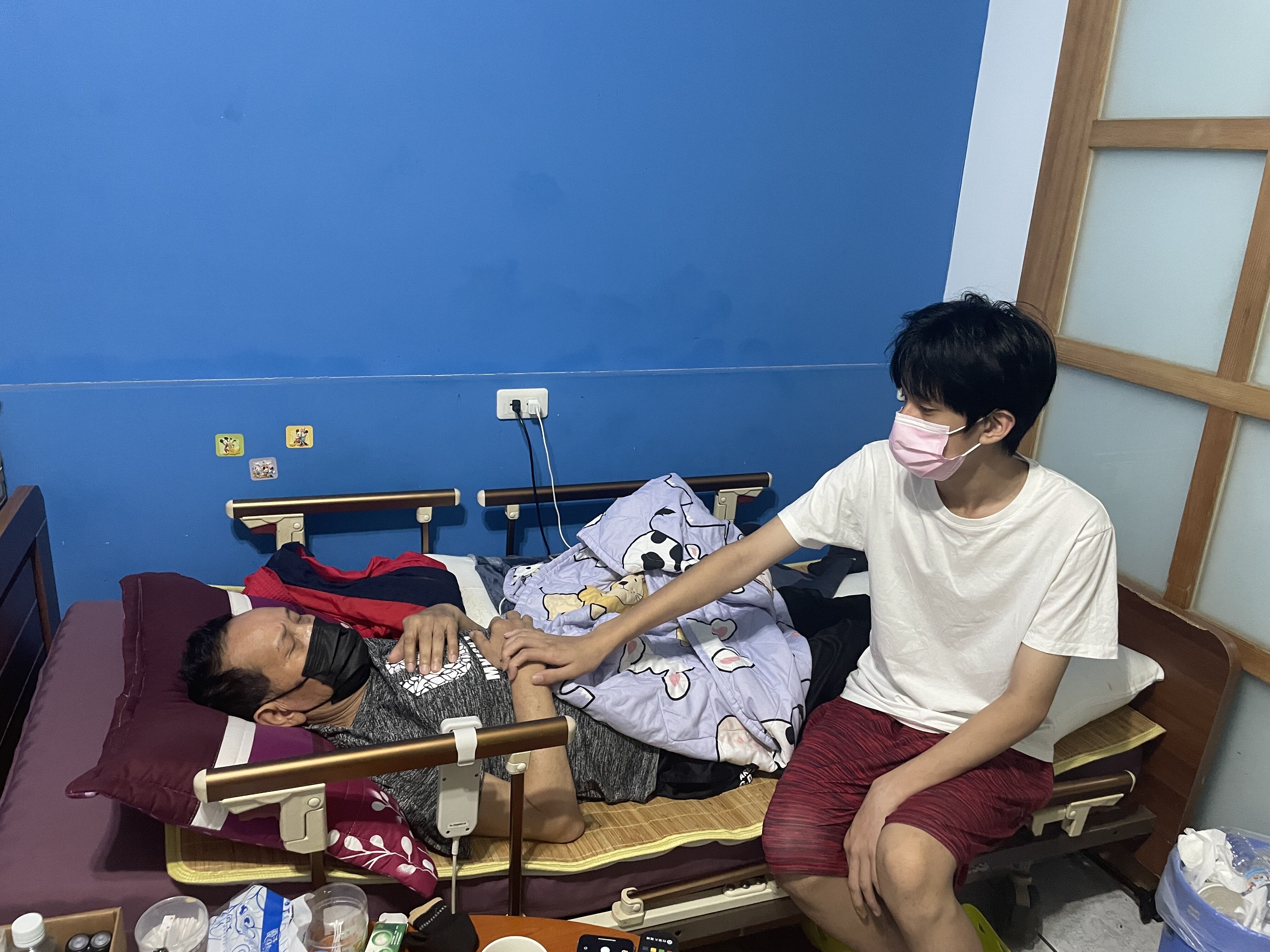 15歲小宗（右）鼓勵病弱父親阿亘（左）要努力復健。李佳玲攝