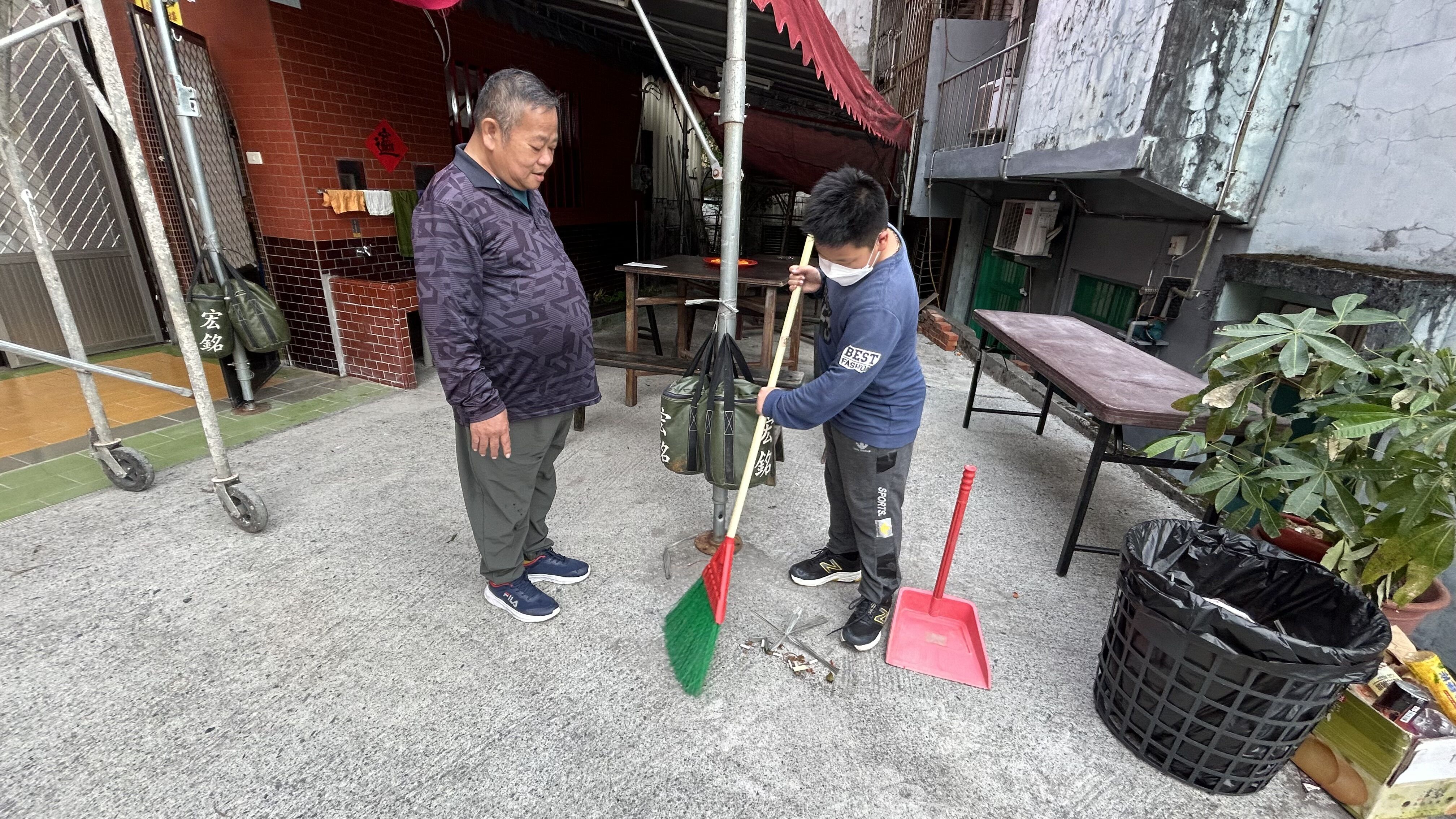 讀小5的小駿（右）早熟懂事，放假會到廟裡幫爸爸清掃工作。仲芝蓉攝