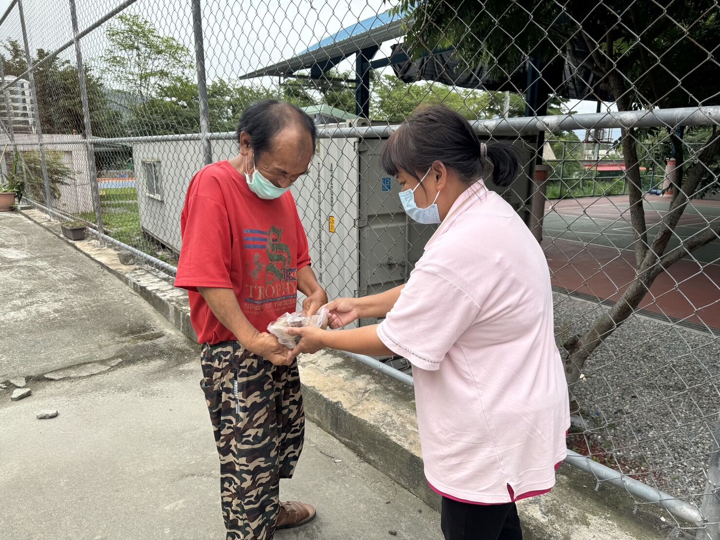 台東愛德婦女協會志工（右）協力發送蘋果慈善基金會愛心粽予海端鄉部落內的弱勢長輩，左為61歲邱伯伯。台東愛德婦女協會提供