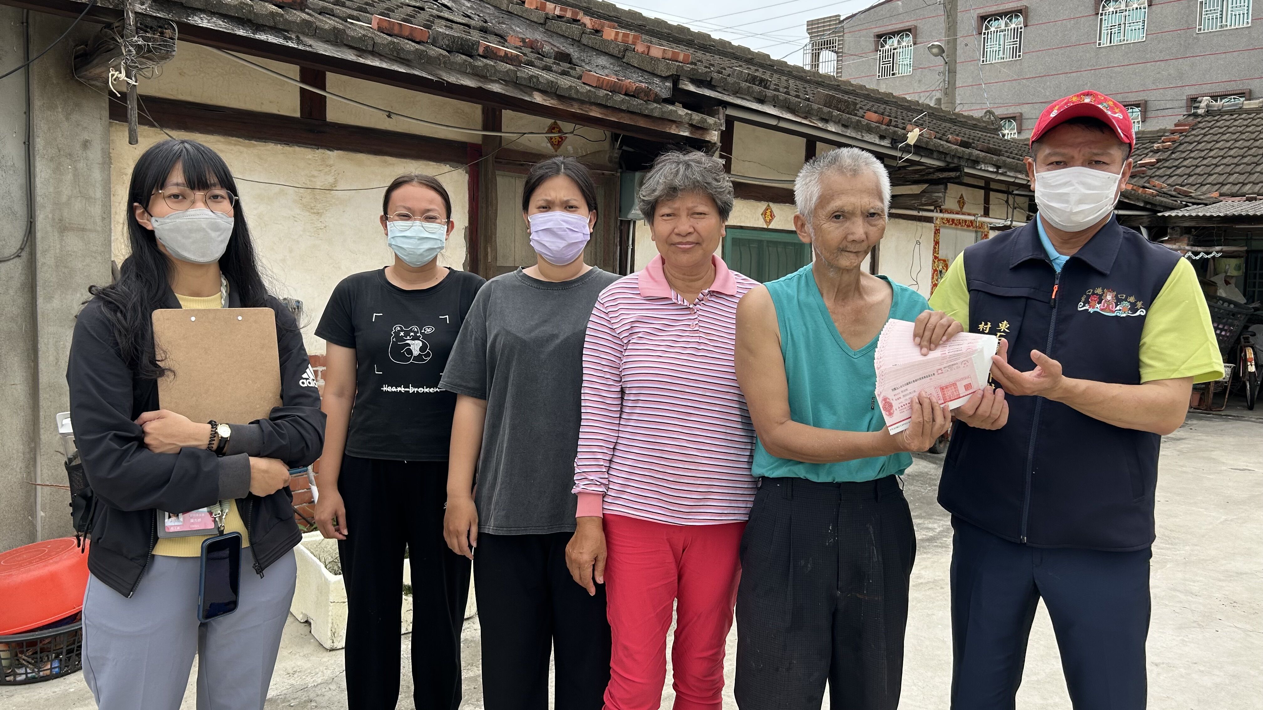 口腔癌復發的61歲阿添（右二）與太太阿蘭（右三）、長女次女（左二、左三）都中度智能障礙，經村長張居雙（右一）及身障個管社工鐘方妤（左一）見證，收下讀者善款。仲芝蓉攝