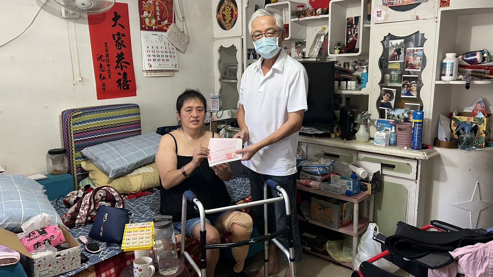 因血栓截肢的49歲阿鬧（左）經村長彭正賢見證，收下讀者善款。仲芝蓉攝