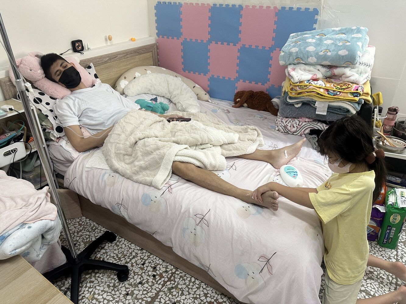 39歲的阿偉(左)虛弱的躺在租住的小套房，9歲升小4的女兒小喬貼心的幫爸爸按摩雙腳。江品璁攝