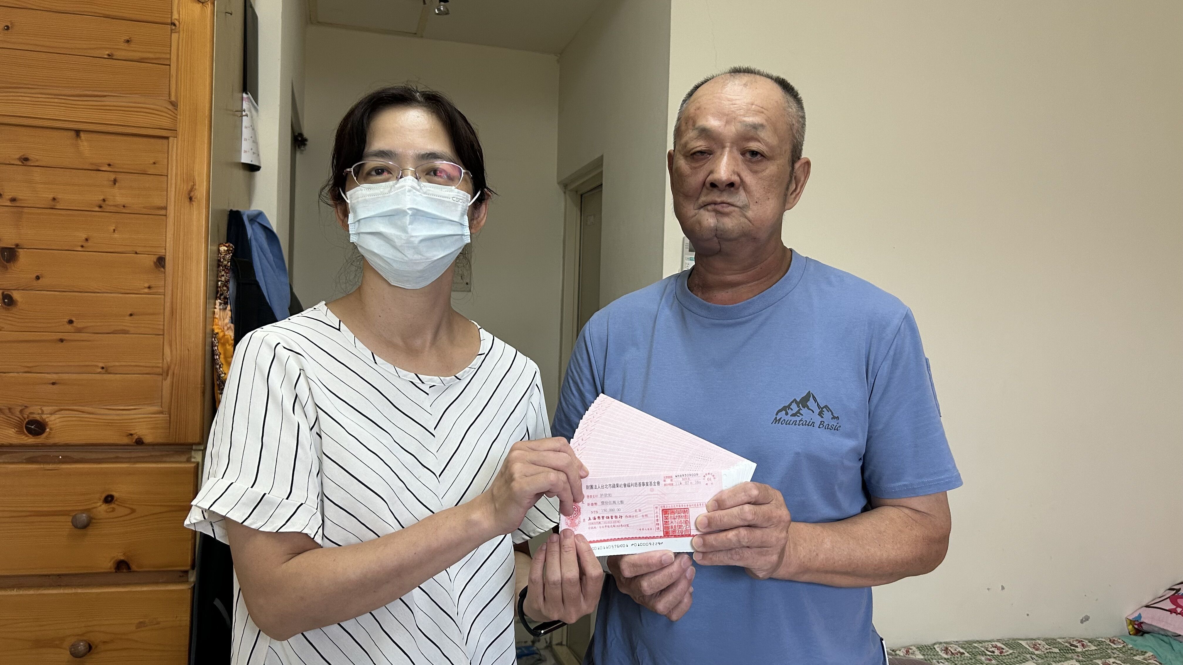 罹黏膜癌四期的66歲阿德（右）經新住民家庭中心社工侯淑芬見證，收下讀者善款。仲芝蓉攝