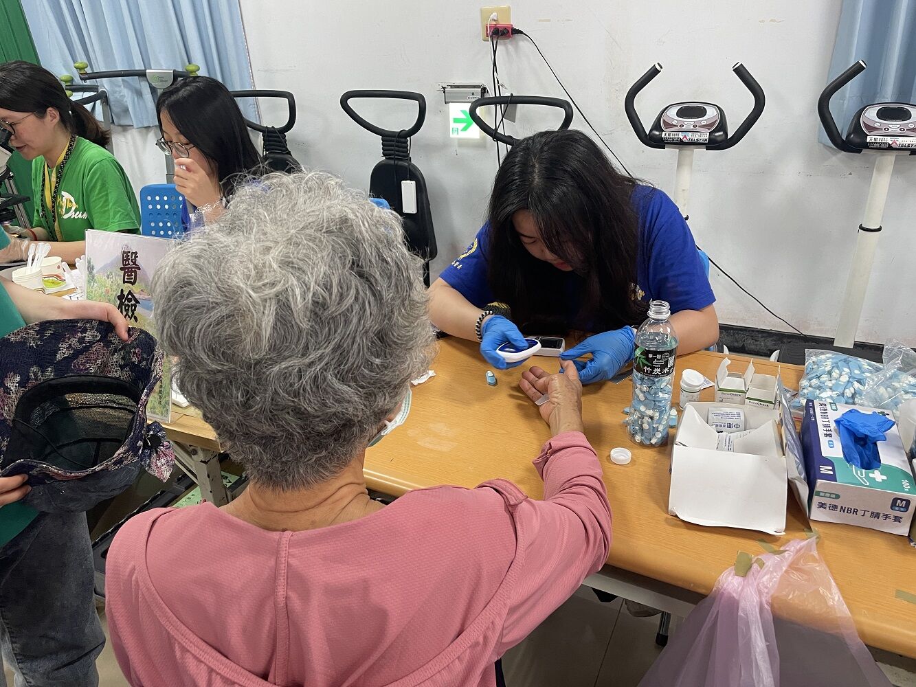 台北醫學大學楓杏醫學青年服務團學生與醫護人員至澎湖進行義診，提供牙科、物理治療等不同項目，此為學生協助長輩進行血糖檢測。李佳玲攝