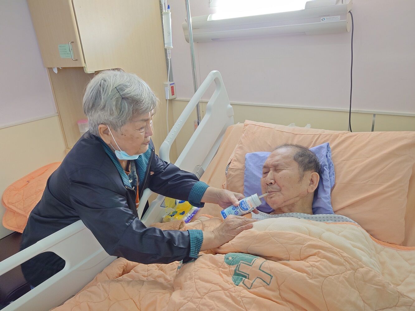 60歲的阿強(右)因罹口腔癌只能靠喝營養品維生，由82歲的媽媽阿妹姨照顧。王雪玲攝