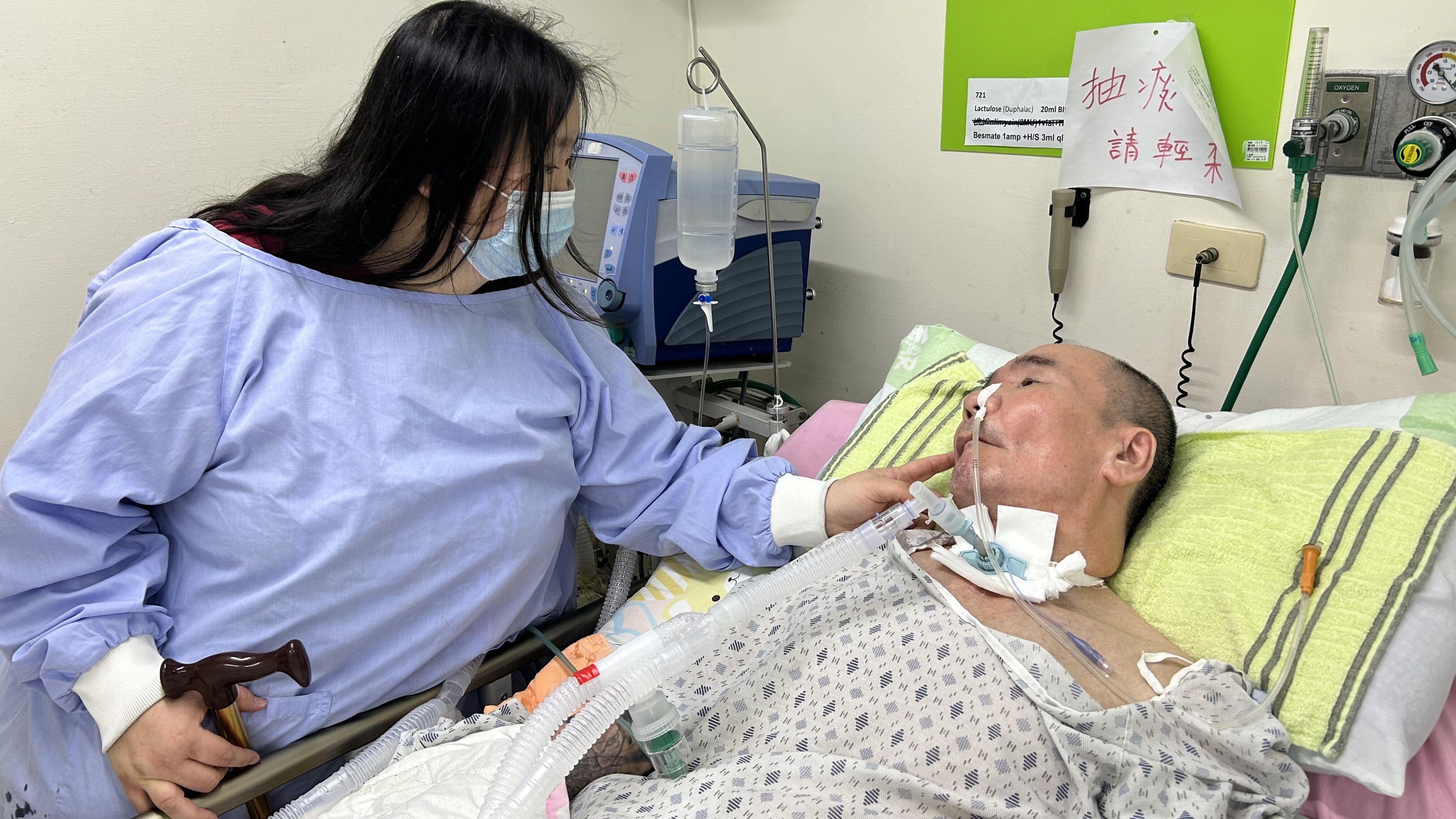 阿芬（左）到呼吸照護病房探望64歲中風癱瘓父親。仲芝蓉攝